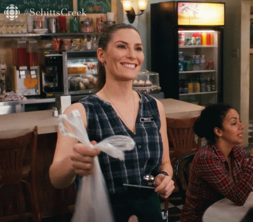 A Woman Wearing A Name Tag That Says Amy Smiles GIF