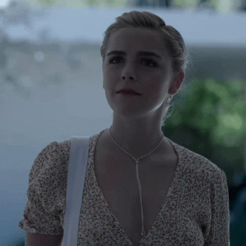 A Woman Wearing A Necklace And A White Bag GIF