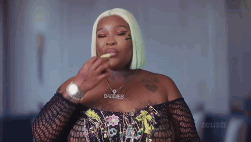 a woman wearing a necklace that says baddies