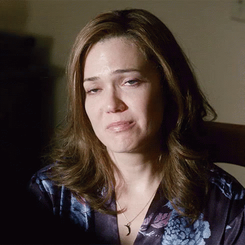 A Woman Wearing A Necklace With A Crescent Moon Pendant Is Crying GIF