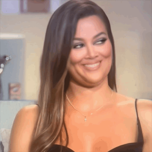 A Woman Wearing A Necklace With A Cross On It GIF