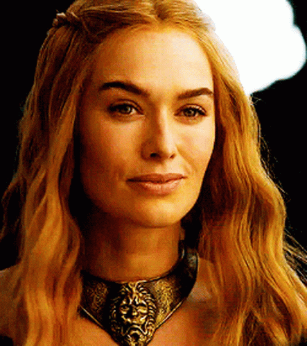 A Woman Wearing A Necklace With A Lion Head On It GIF