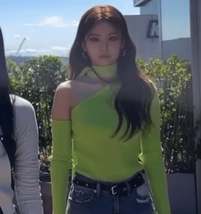 A Woman Wearing A Neon Green Off The Shoulder Sweater GIF