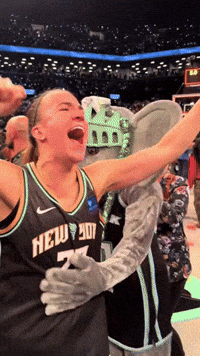 A Woman Wearing A New York Jersey Celebrates With A Mascot GIF