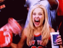 A Woman Wearing A New York Jersey Is Holding A Cup Of Soda GIF