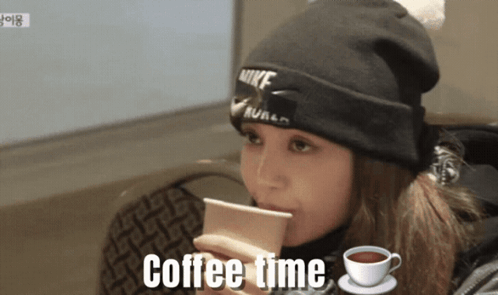A Woman Wearing A Nike Beanie Is Drinking Coffee GIF