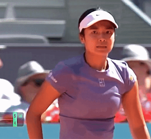 A Woman Wearing A Nike Hat And A Purple Shirt With The Number 4 On The Bottom GIF