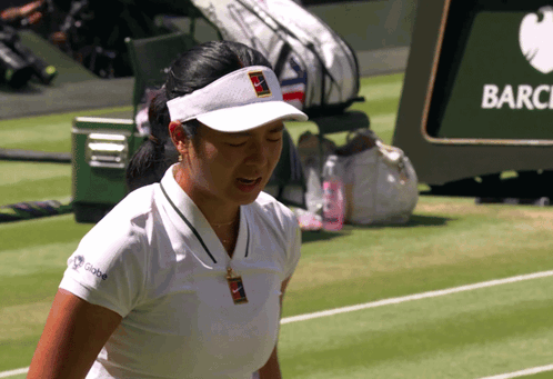 A Woman Wearing A Nike Visor Stands On A Tennis Court With Her Eyes Closed GIF