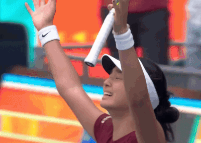 A Woman Wearing A Nike Wristband Is Holding A Tennis Racquet In Her Hand GIF