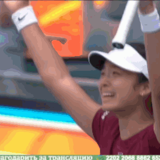 A Woman Wearing A Nike Wristband Is Holding A Tennis Racquet In Her Hands GIF