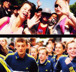 A Woman Wearing A Ny Hat Stands In Front Of A Crowd GIF