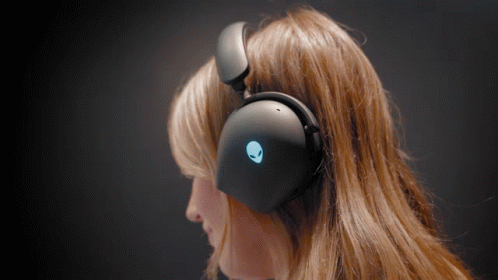 A Woman Wearing A Pair Of Black Headphones With An Alien Logo On Them GIF