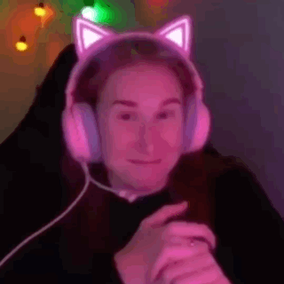 a woman wearing a pair of pink cat ears headphones is sitting in a chair .