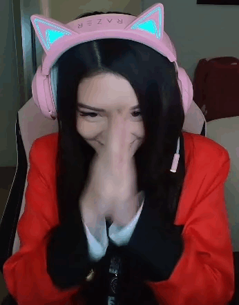 A Woman Wearing A Pair Of Pink Headphones With Cat Ears Is Covering Her Nose . GIF