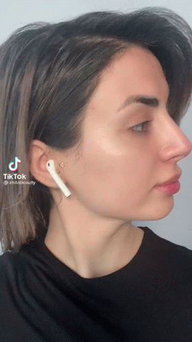 A Woman Wearing A Pair Of White Ear Buds Has A Tiktok Icon On Her Face GIF
