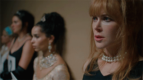 A Woman Wearing A Pearl Necklace Stands In A Line With Other Women GIF