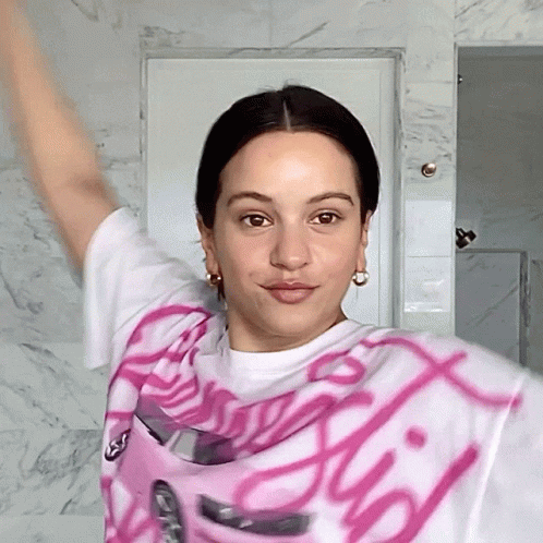 A Woman Wearing A Pink And White Shirt That Says ' Barbie ' GIF