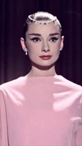 Woman In Pink Dress And Earrings Looking At Camera GIF