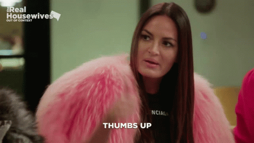A Woman Wearing A Pink Fur Coat And A Black Balenciaga Shirt Says Thumbs Up GIF