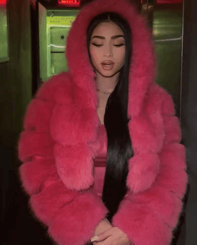 A Woman Wearing A Pink Fur Coat With A Hood GIF