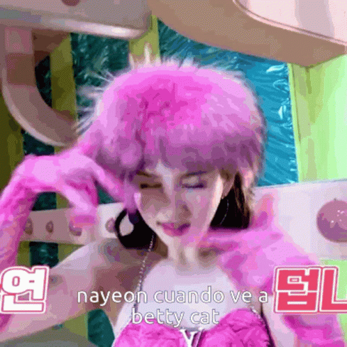 A Woman Wearing A Pink Fur Hat And Gloves With The Words Nayeon Cuando Ve A Betty Cat Below Her GIF