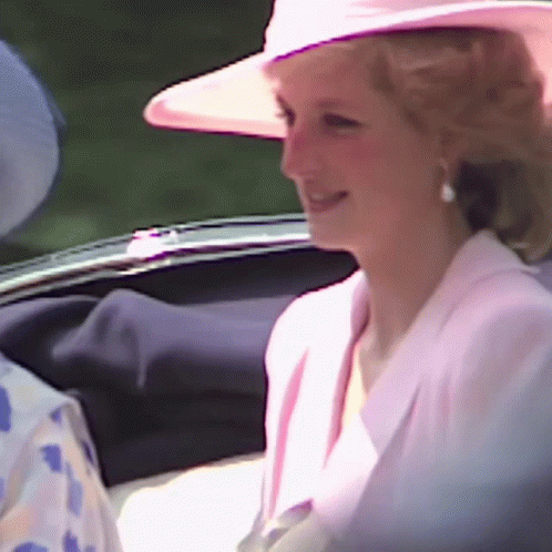 A Woman Wearing A Pink Hat And A White Jacket Is Smiling GIF