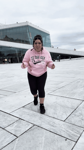 A Woman Wearing A Pink Hoodie That Says Cole Emmy Igen On It GIF