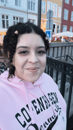 A Woman Wearing A Pink Hoodie That Says Copenhagen On It GIF