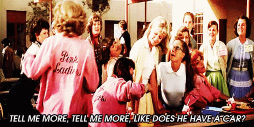 A Woman Wearing A Pink Jacket That Says Pink Ladies Stands In Front Of A Group Of Women GIF