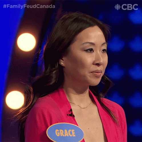A Woman Wearing A Pink Shirt And A Name Tag That Says Grace GIF