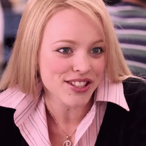 A Woman Wearing A Pink Shirt And A Necklace With The Letter P On It GIF