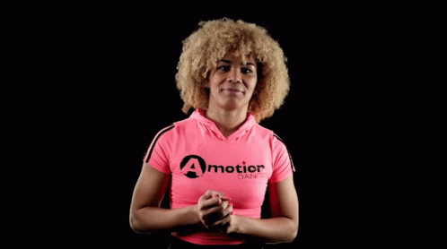 A Woman Wearing A Pink Shirt That Says A Motion Dance On It GIF