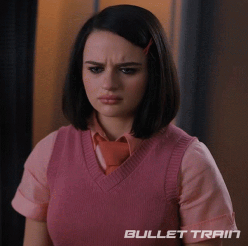 A Woman Wearing A Pink Vest And Tie With Bullet Train Written On The Bottom Right GIF