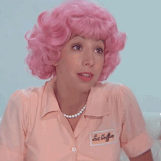A Woman Wearing A Pink Wig And A Pink Shirt Has A Name Tag On Her Shirt That Says Les Coiffures GIF