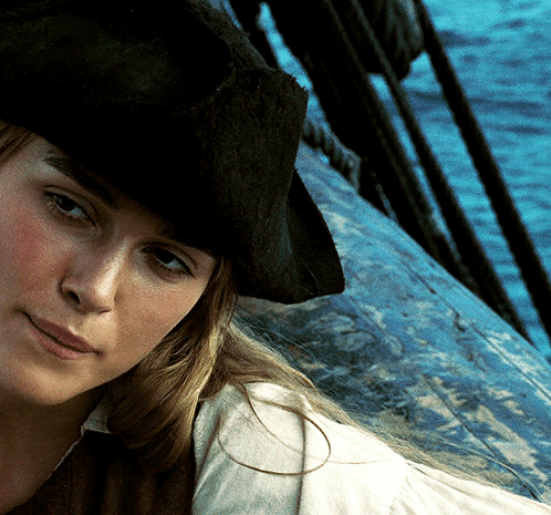A Woman Wearing A Pirate Hat Is Looking At The Camera GIF