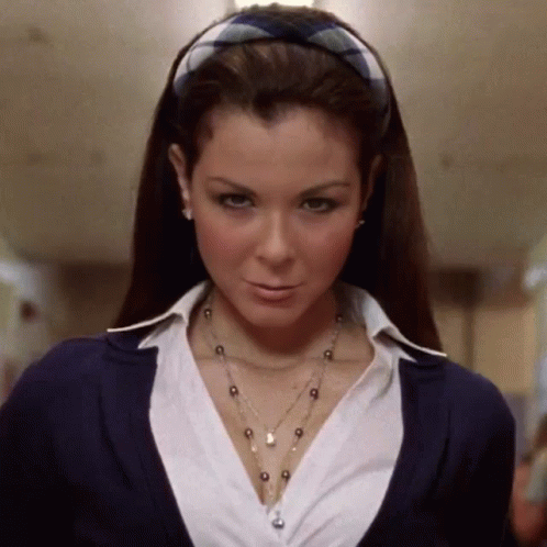 A Woman Wearing A Plaid Headband And A Necklace GIF