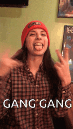 A Woman Wearing A Plaid Shirt And A Red Hat Is Making A Funny Face With The Words Gang Gang Written Below Her GIF