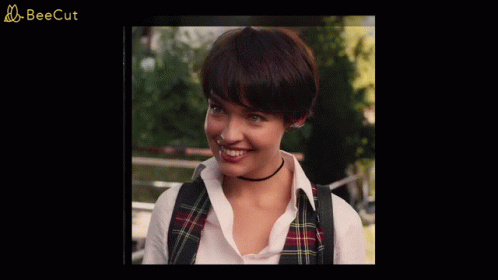 A Woman Wearing A Plaid Vest And A Choker Smiles In A Beecut Ad GIF