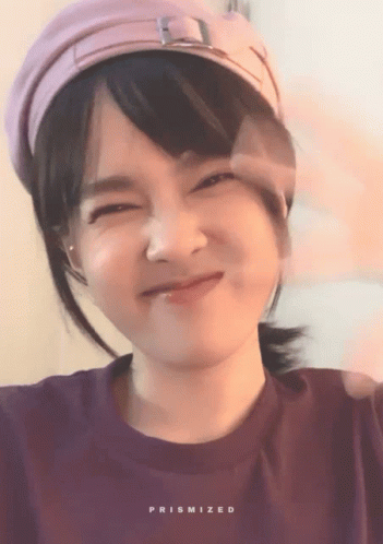Woman In Purple Shirt And Pink Hat With Prismized Text GIF