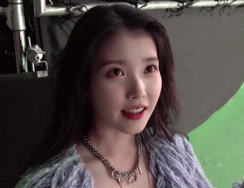 a woman wearing a purple sweater and a necklace with the word gucci on it