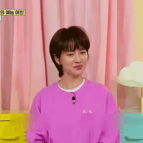 A Woman Wearing A Purple Sweatshirt With A Microphone On Her Neck GIF