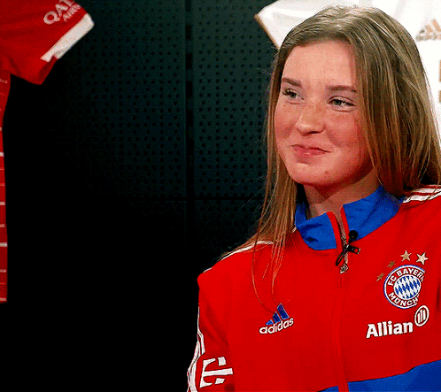 A Woman Wearing A Red Adidas Jacket With The Word Allian On It GIF