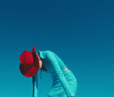 A Woman Wearing A Red Cowboy Hat And A Blue Dress GIF