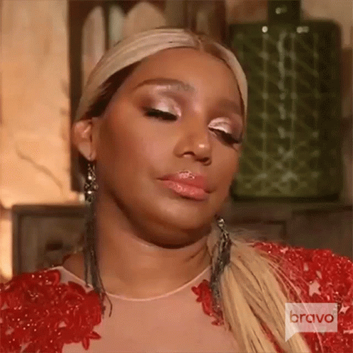 A Woman Wearing A Red Dress And Earrings Is Making A Face . GIF