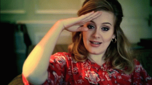 A Woman Wearing A Red Floral Shirt Is Making A Funny Face GIF