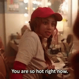 A Woman Wearing A Red Hat Is Sitting At A Desk And Says You Are So Hot Right Now . GIF