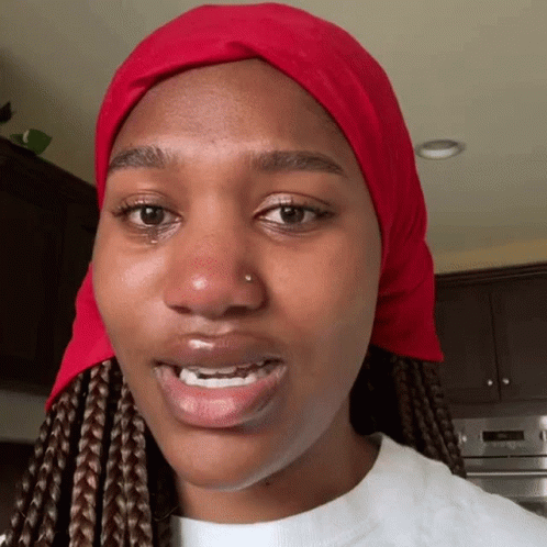 A Woman Wearing A Red Scarf Around Her Head GIF