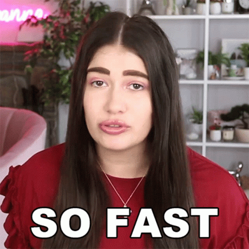 A Woman Wearing A Red Shirt And Necklace Says So Fast GIF