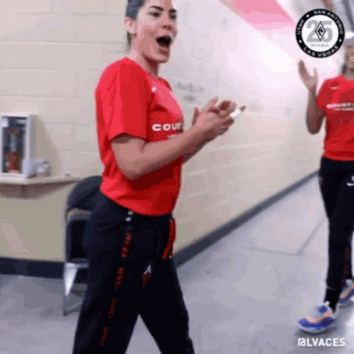 A Woman Wearing A Red Shirt That Says Court Is Standing In A Hallway GIF