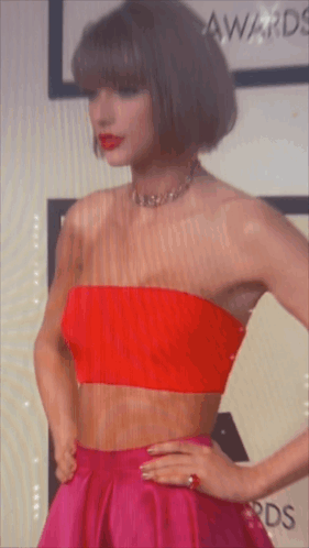 A Woman Wearing A Red Strapless Top And A Pink Skirt GIF